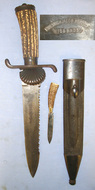 RARE**QUALITY**Late 19th Century Imperial German ‘Friedrich Jacob Bartels Wiesbaden’ Clamshell Boar & Stag Hunting Dagger / Dirk / Sidearm With Hunting Scenes Etched Sawback Blade, Stag Antler Hilt & Original Steel Mounted Leather Scabbard With Skinne Hunting Knive