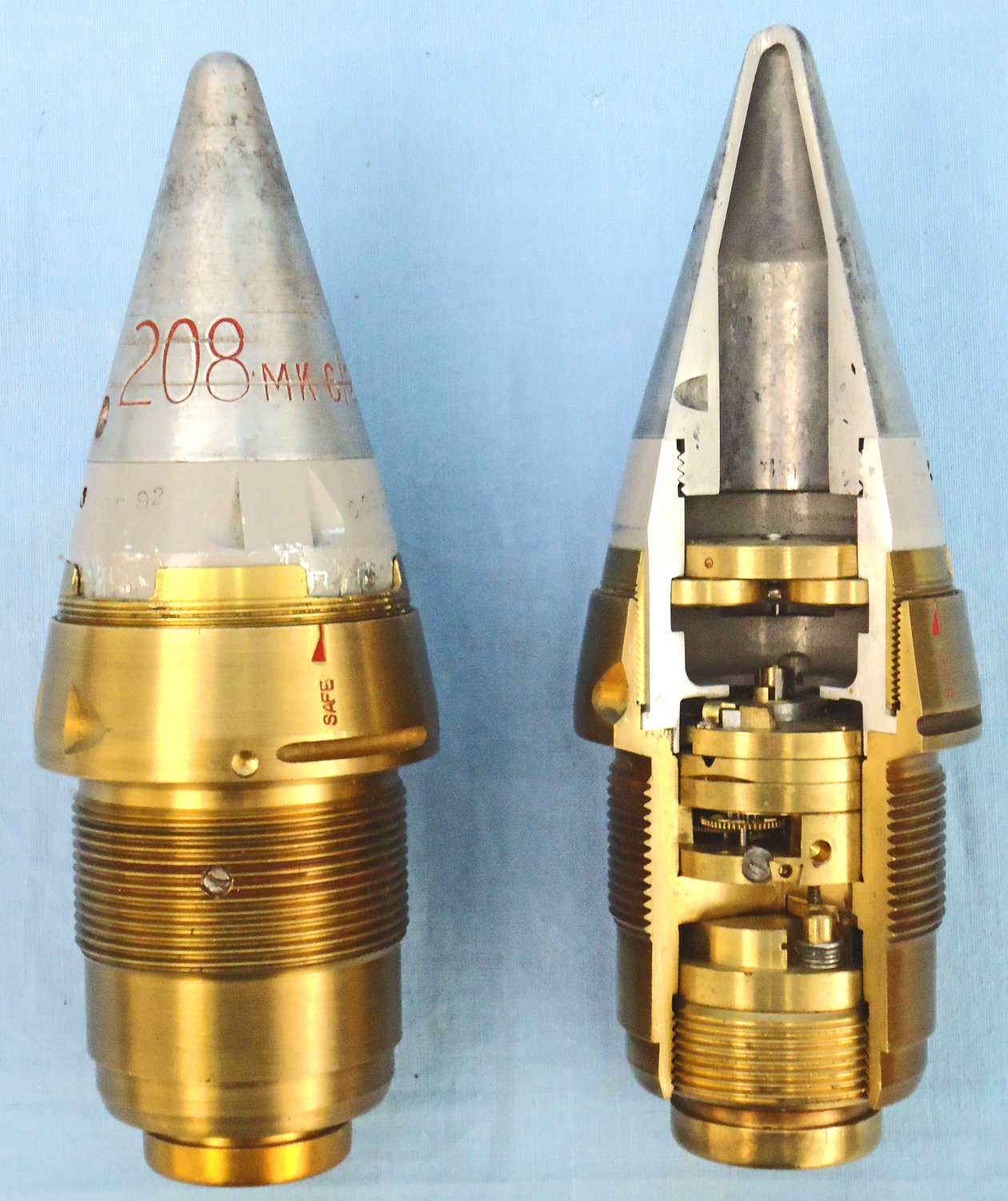  INERT. Pair Of Unfired British No 208 Mk 6/2 Clockwork Fuzes Converted To No 208 Mk 8/1 Fuzes. One In A Quarter Section & One Unsectioned For The British 3.7, 4.5 & 5.25 Inch Anti-aircraft Gun. Inch Anti-aircraft Guns On A Mahogany Display Plinth. - O 195 INERT. Pair Of Unfired British No 208 Mk 6/2 Clockwork Fuzes Converted To No 208 Mk 8/1 Fuzes. One In A Quarter Section & One Unsectioned For The British 3.7, 4.5 & 5.25 Inch Anti-aircraft Gun. Inch Anti-aircraft Guns On A Mahogany Display Plinth. - O 195  Other Ammunition