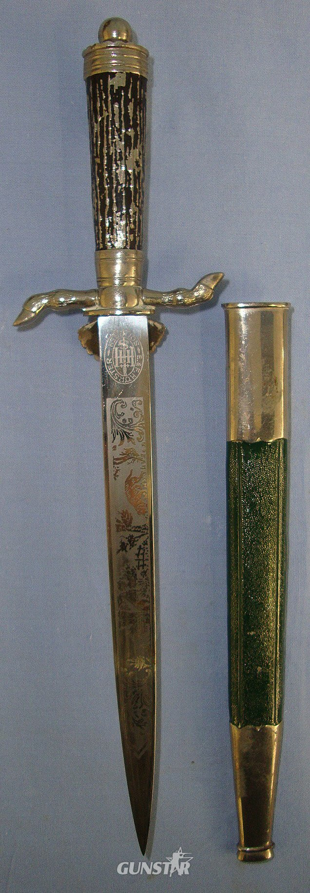  1934 – 1945 WW2 Era Nazi German Deutsche Jägerschaft (German Hunting Society) Badged, E&F Horster Solingen Miniature Clamshell Stag Hunting Dagger / Dirk With Hunting Scenes Blued & Etched Blade, Cast Alloy Hilt & Scabbard. Sn 23459  Dagger